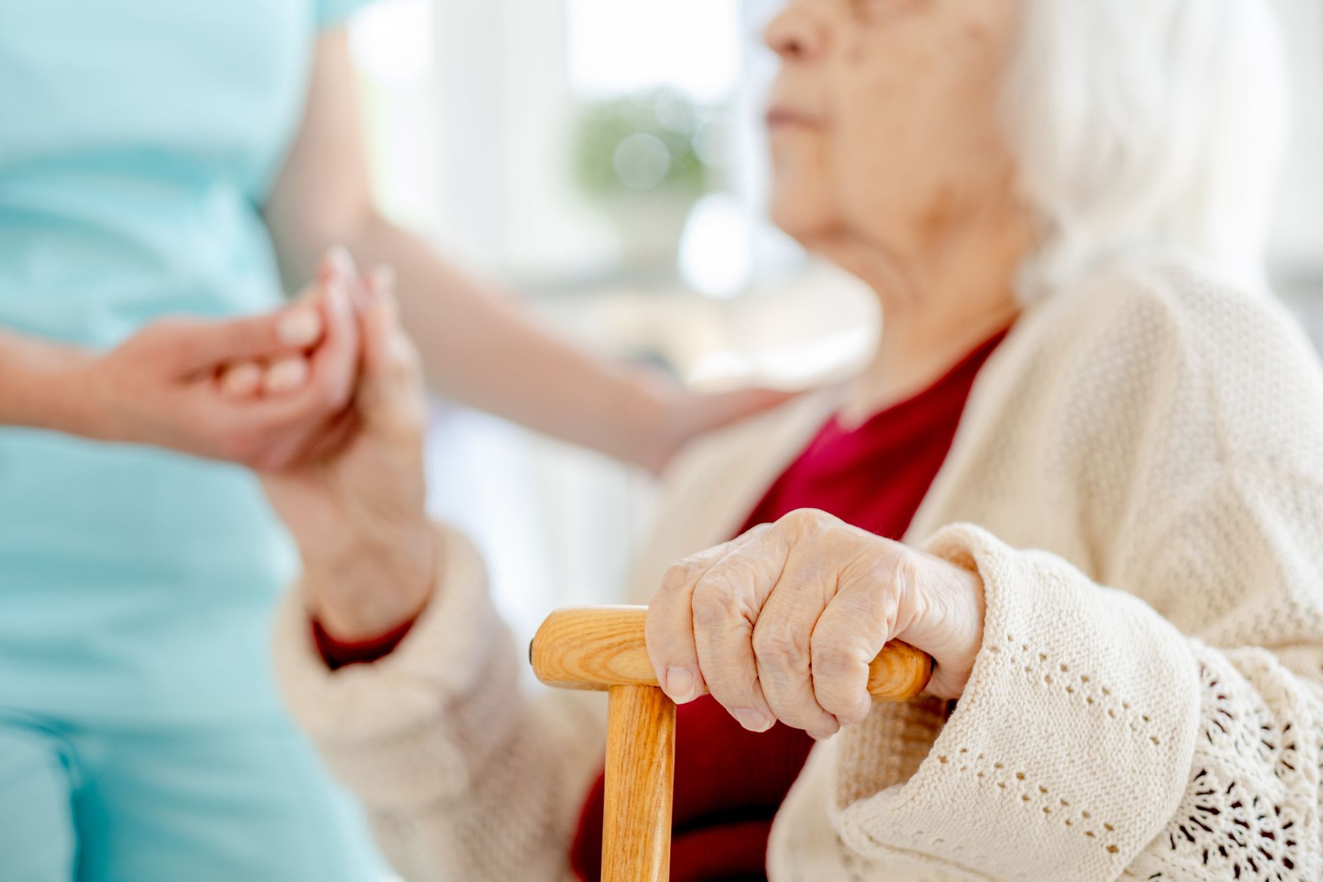 Nurse holding an elderly patient’s hand